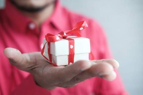 A man holding a small gift in his palm