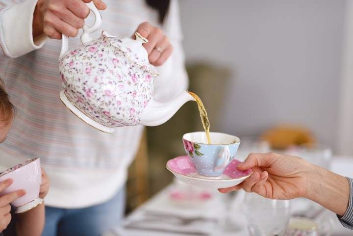 Someone pouring tea in a teacup