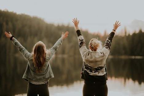 Women holding their hands up in the air in joy